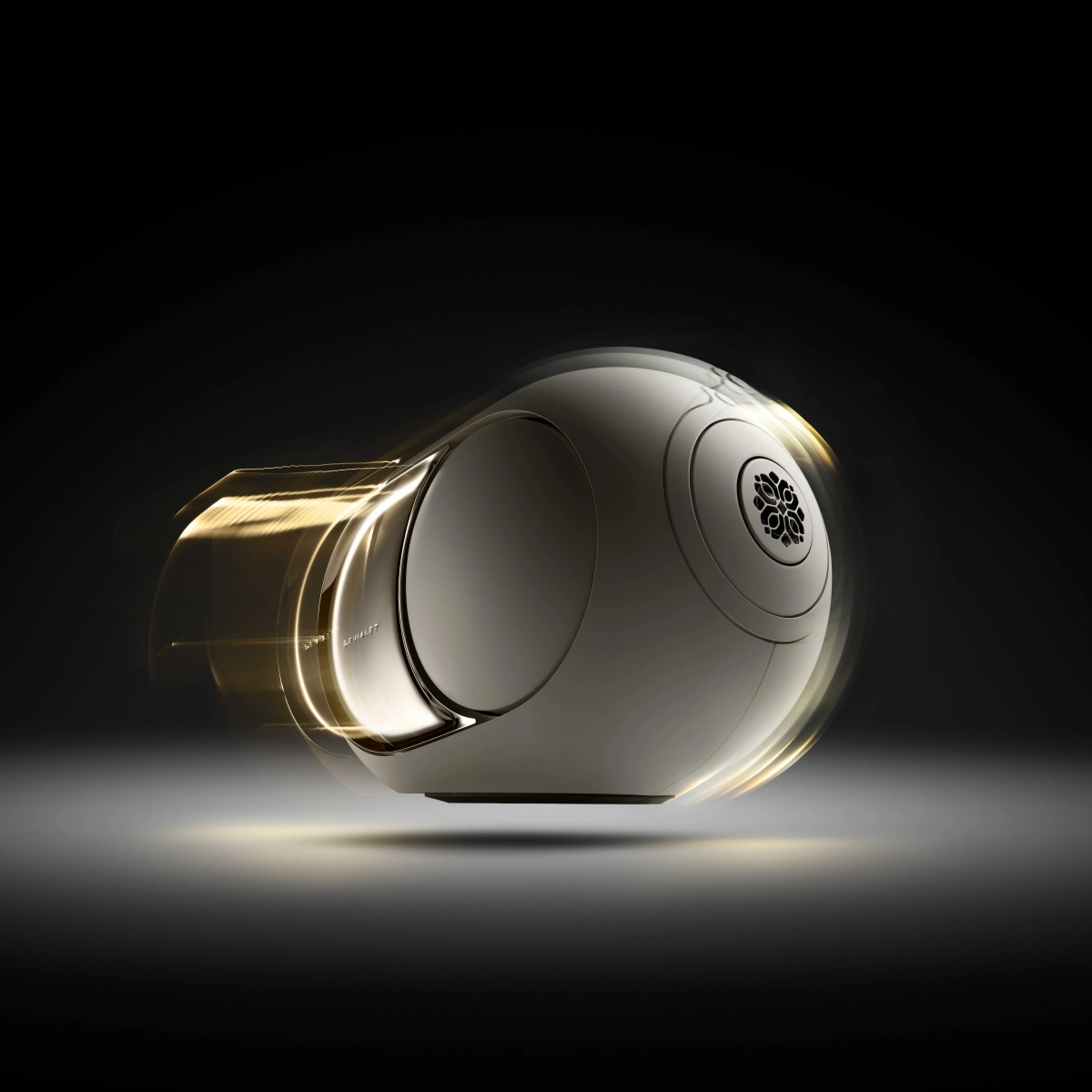 Devialet Phantom Ultimate 108 dB Opéra de Paris v zlatém provedení s rozmazanými bočními wooferdy zachycenými v pohybu