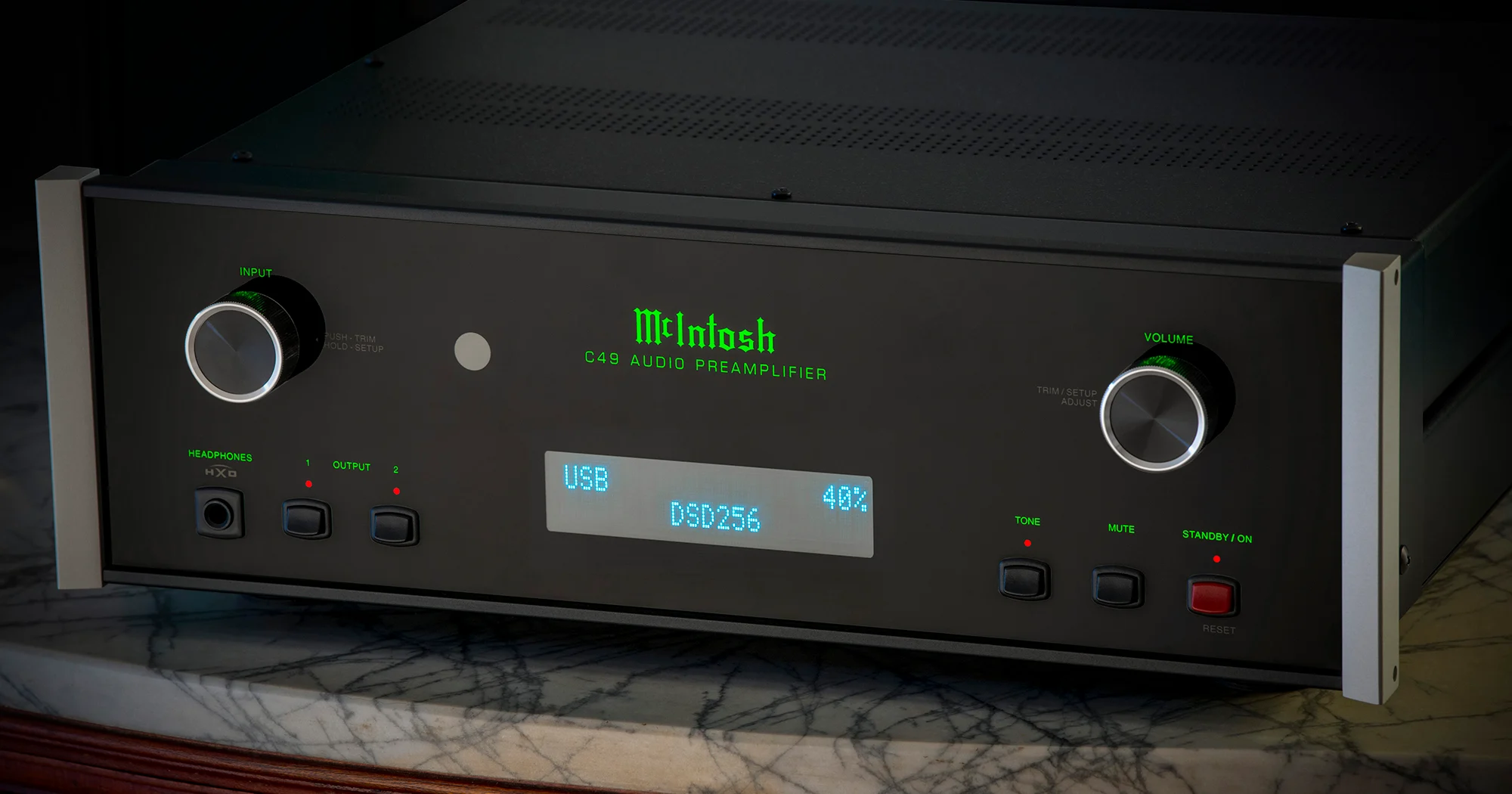 McIntosh C49 stojící na mramorovém stolku, na displeji svítí zeleně USB a DSD256 — předzesilovač v elegantním obytném interiéru