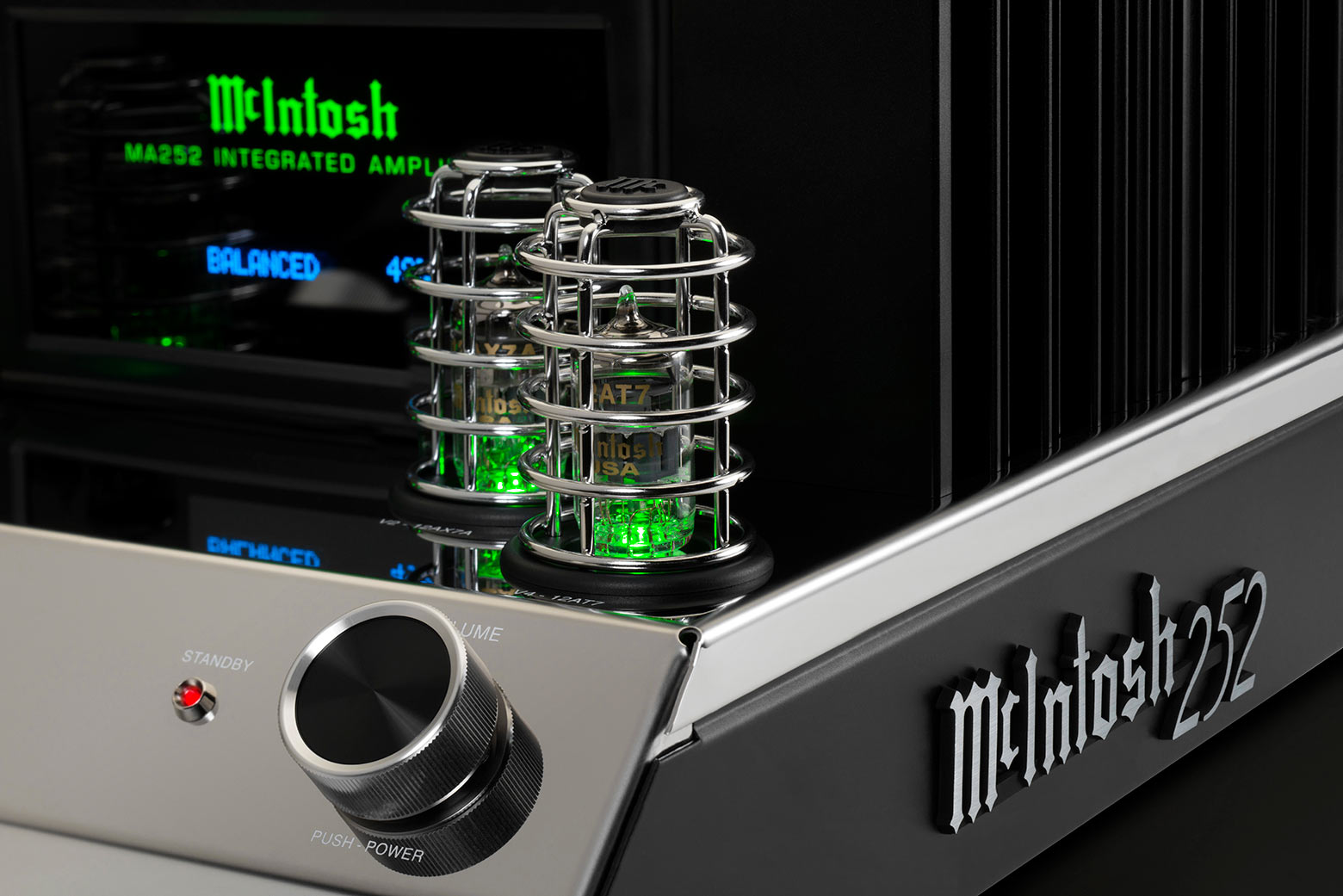 Detail elektronek 12AX7A a 12AT7 v chromovaných klíckách se zeleným nasvícením a štítkem McIntosh 252