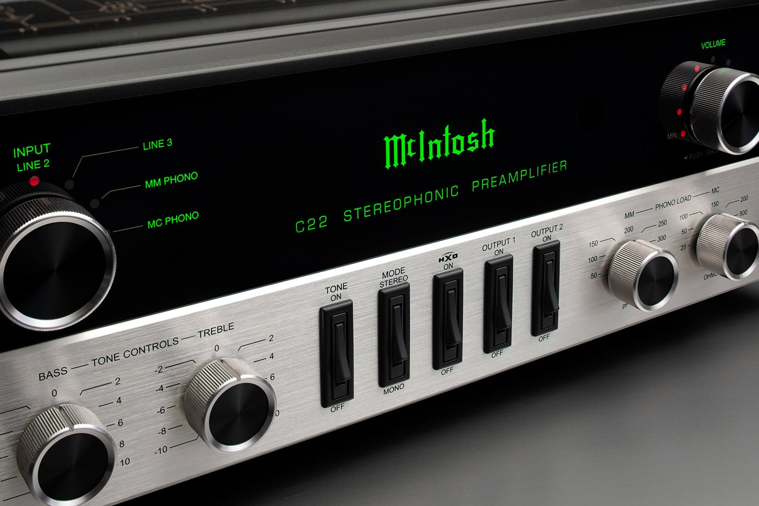 Detail předního panelu McIntosh C22 Mk V se zeleným nápisem C22 Stereophonic Preamplifier, přepínači tónů, výstupů a knoflíky phono load