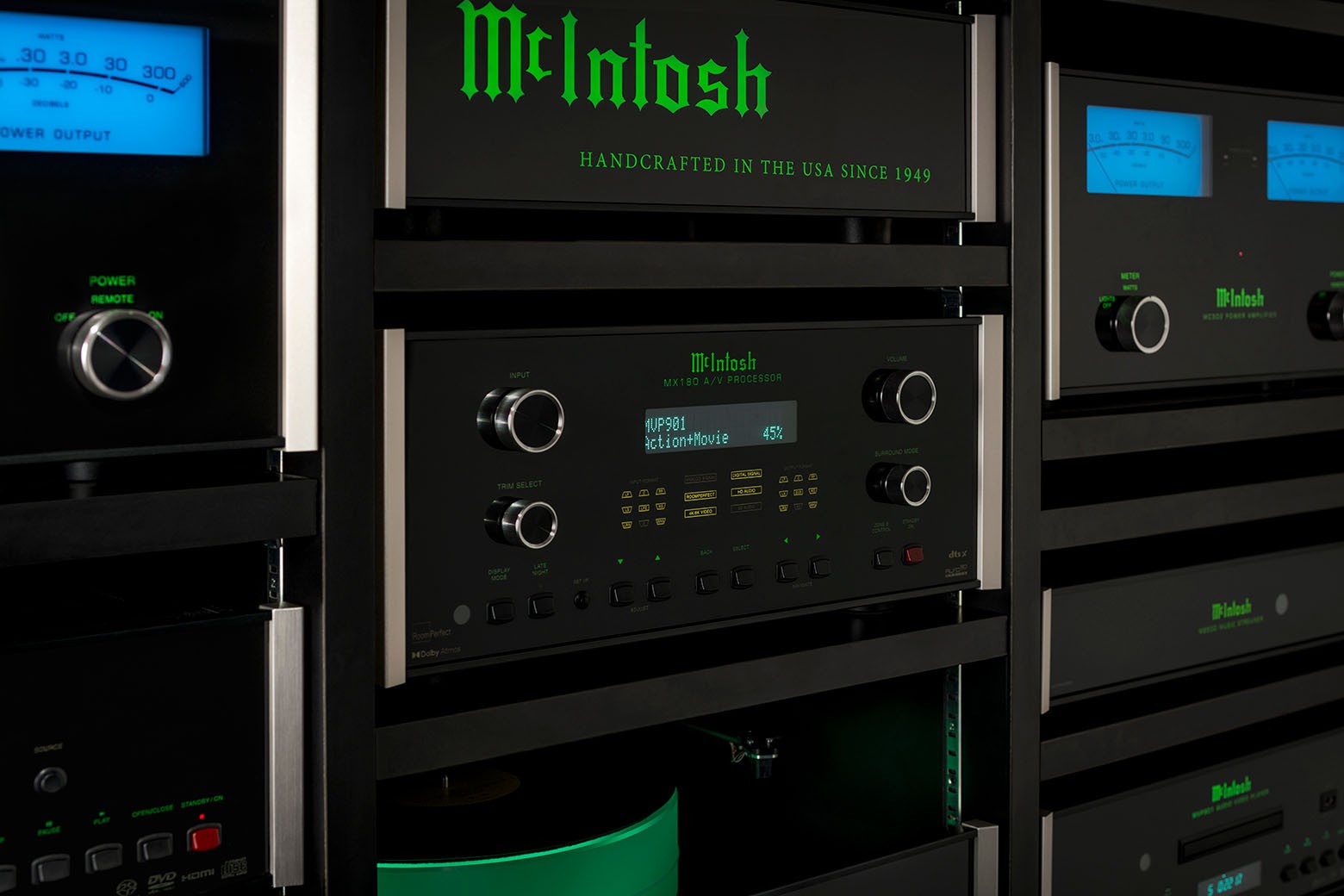 McIntosh MX180 v sestavě komponentů McIntosh se zeleně podsvíceným nápisem a modře svítícími měřidly výkonu