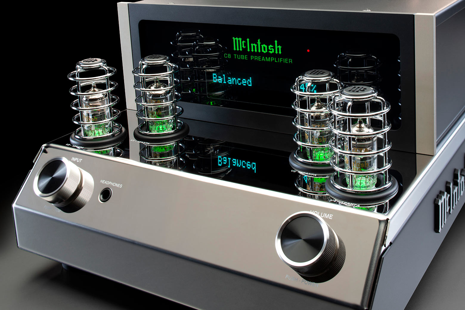 Detail černého skleněného předního panelu McIntosh C8 s podsvíceným logem a otočnými knoflíky