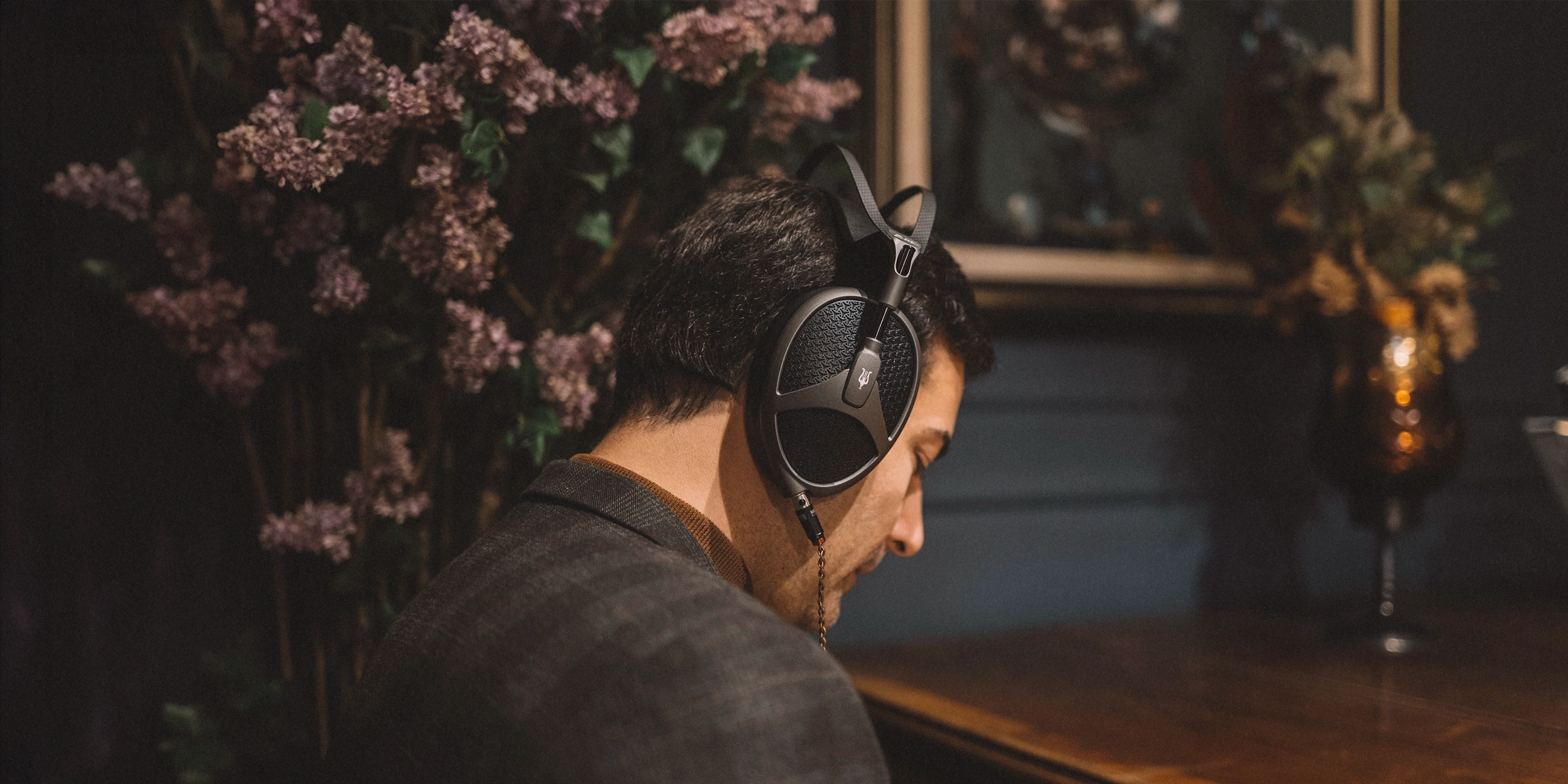 Vlajková náhlavní sluchátka Meze Audio Elite Tungsten s hluboce černou CNC frézovanou mřížkou v atmosférickém záběru