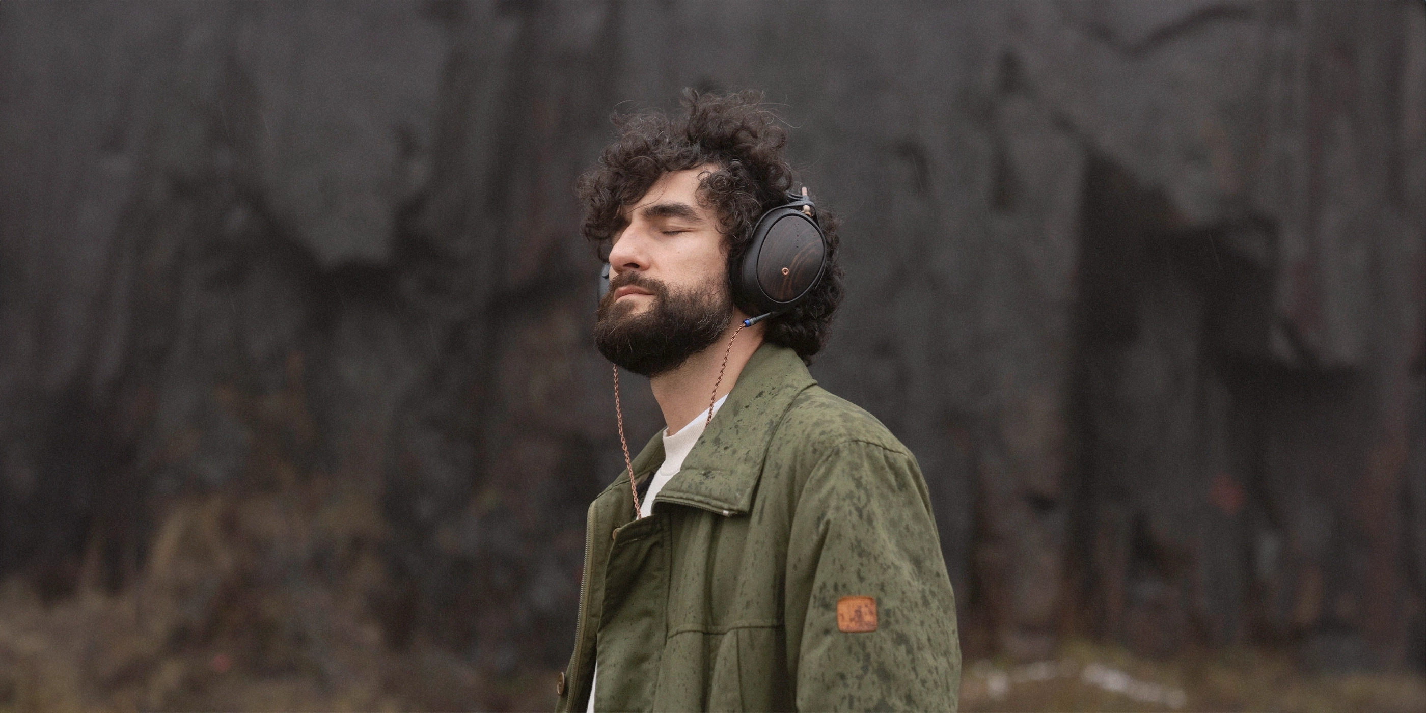 Muž s nasazenými uzavřenými sluchátky Meze Audio Liric 2 ve venkovním prostředí