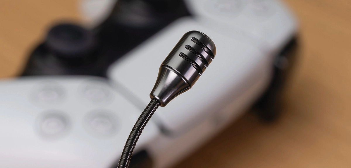 Detail hliníkového krytu mikrofonu Meze Audio Boom Mic s ohebným ramenem nad herním ovladačem