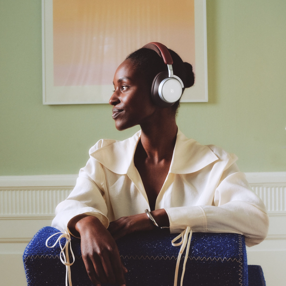 Detail titanového měniče Beoplay H100 Century Brown za hliníkovou mřížkou
