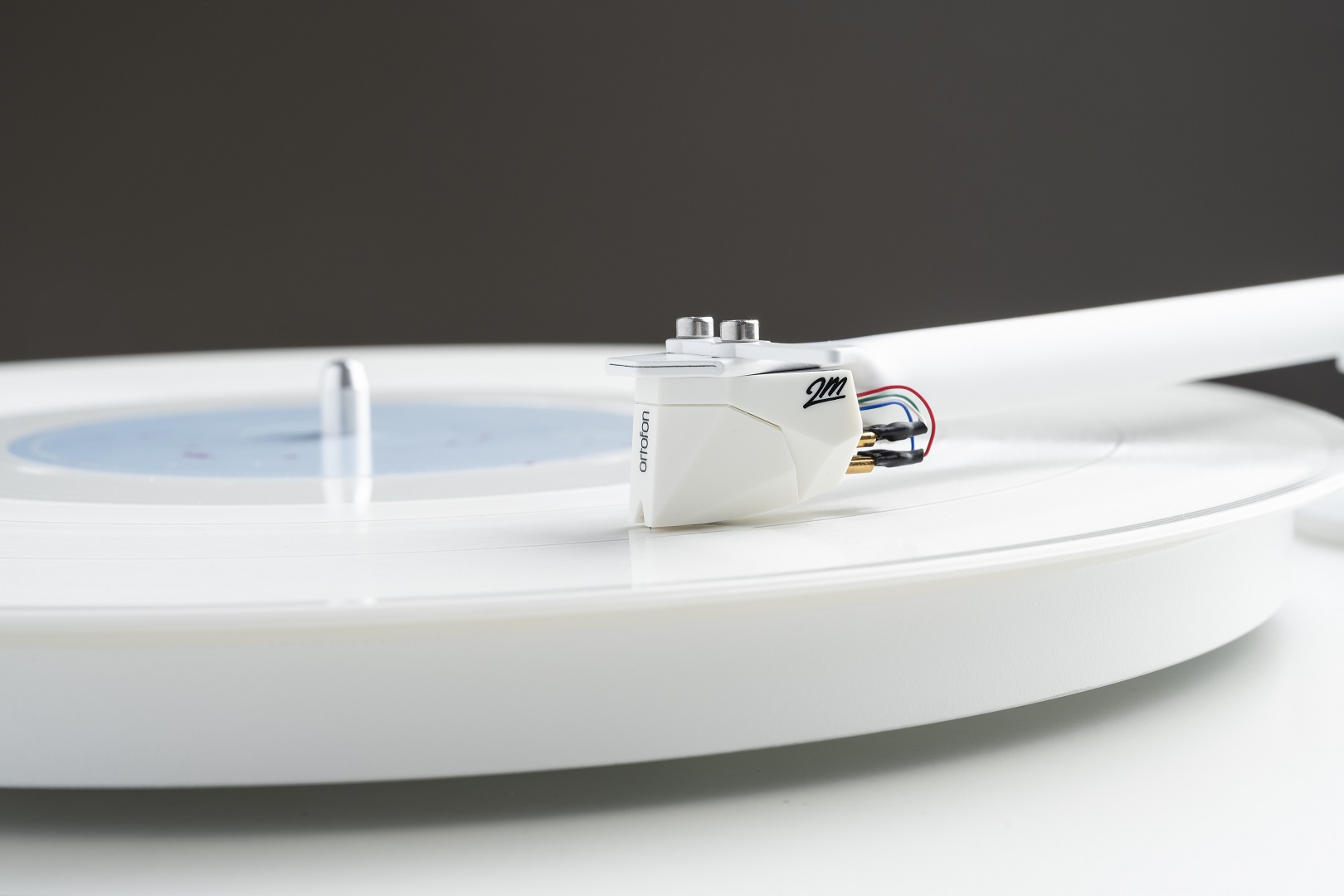 Pro-Ject T1 White Edition v bílém provedení z dalšího úhlu, s bílým ramenem a talířem s plstěnou podložkou
