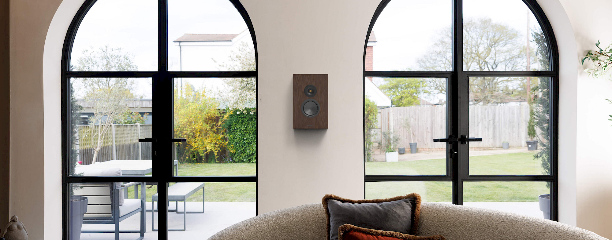 Monitor Audio Silver On-Wall 8G v dýze European Walnut zavěšený na stěně mezi klenutými prosklenými dveřmi