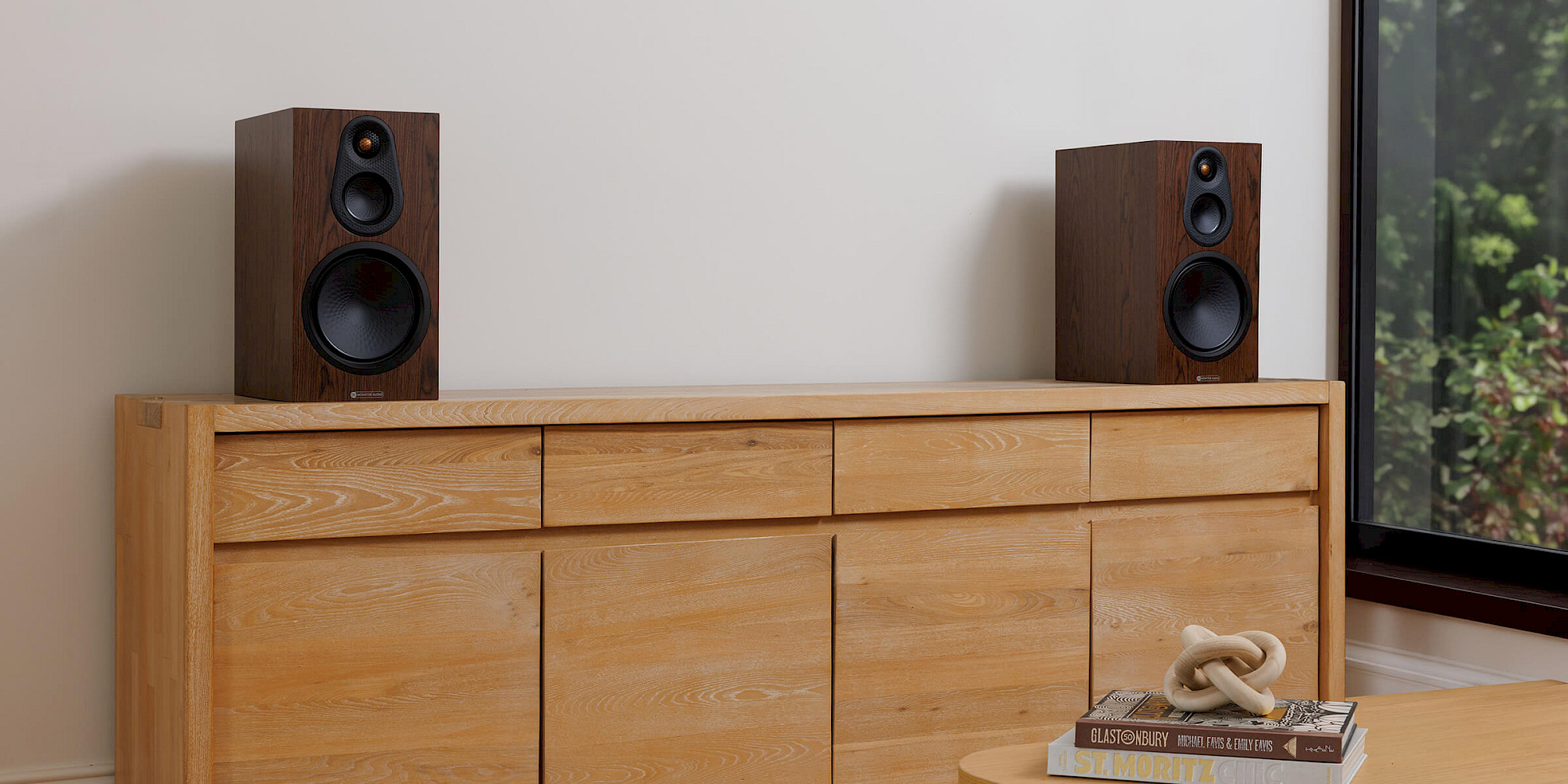 Dvojice regálových reproduktorů řady Silver 8G v dýze European Walnut na dubové komodě