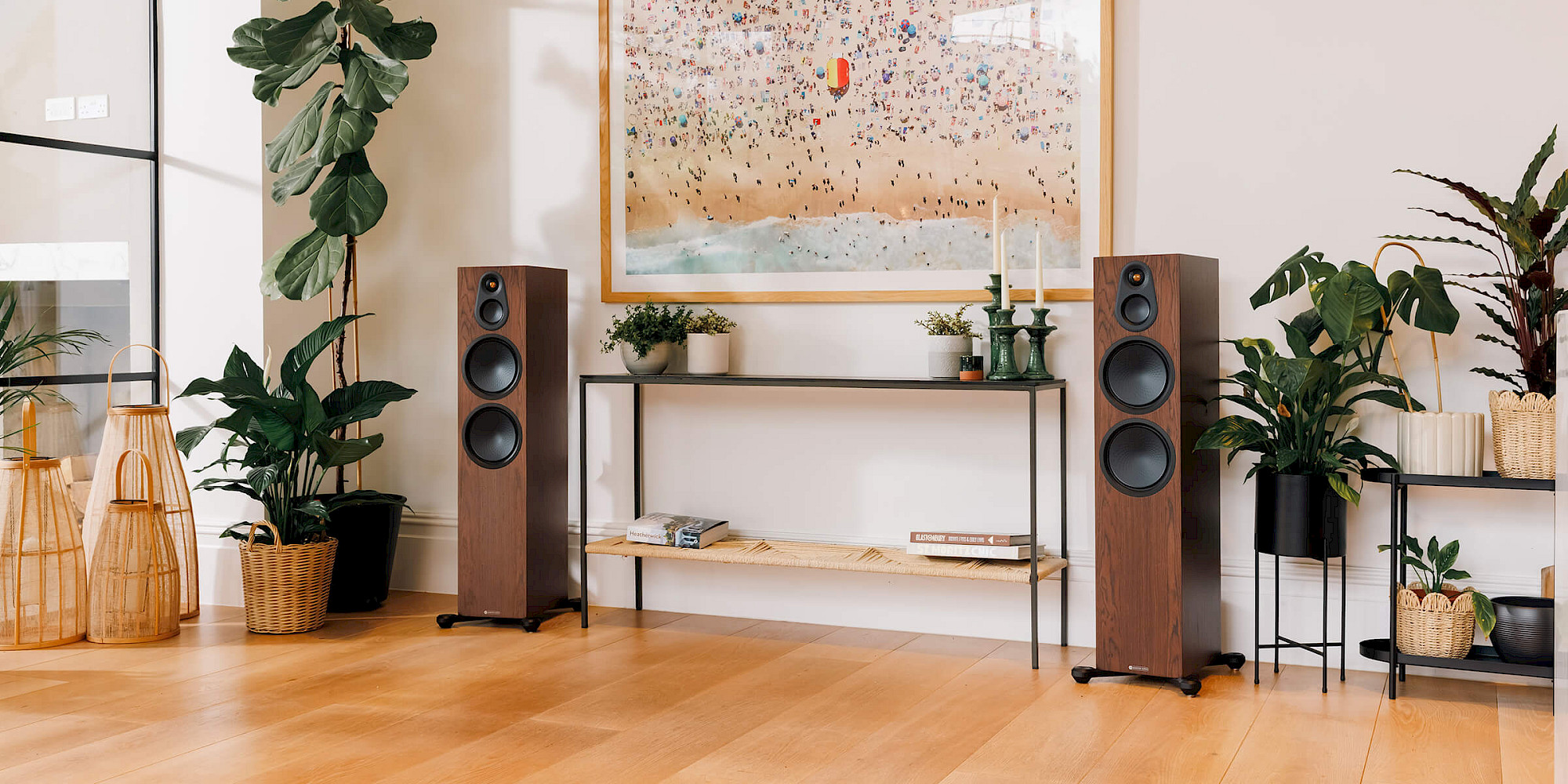 Pár sloupových reproduktorů řady Silver 8G v dýze European Walnut v obývacím pokoji s rostlinami