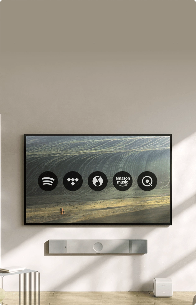 Televize s ikonami streamovacích služeb Spotify a TIDAL a soundbarem KEF XIO pod ní