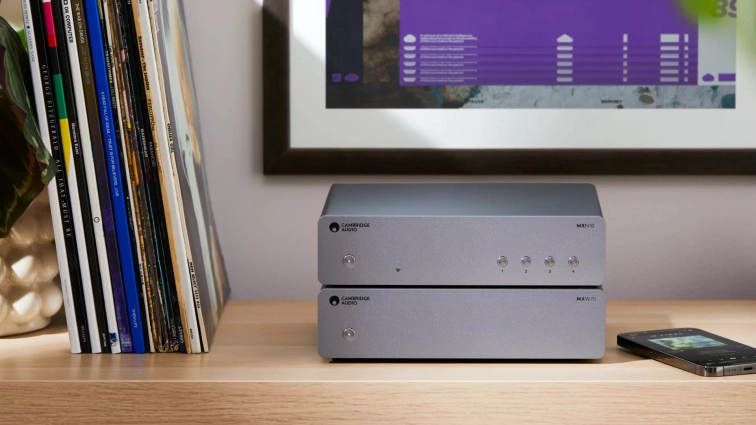 Cambridge Audio MXW70 se síťovým streamerem MXN10 na psacím stole vedle sbírky gramofonových desek