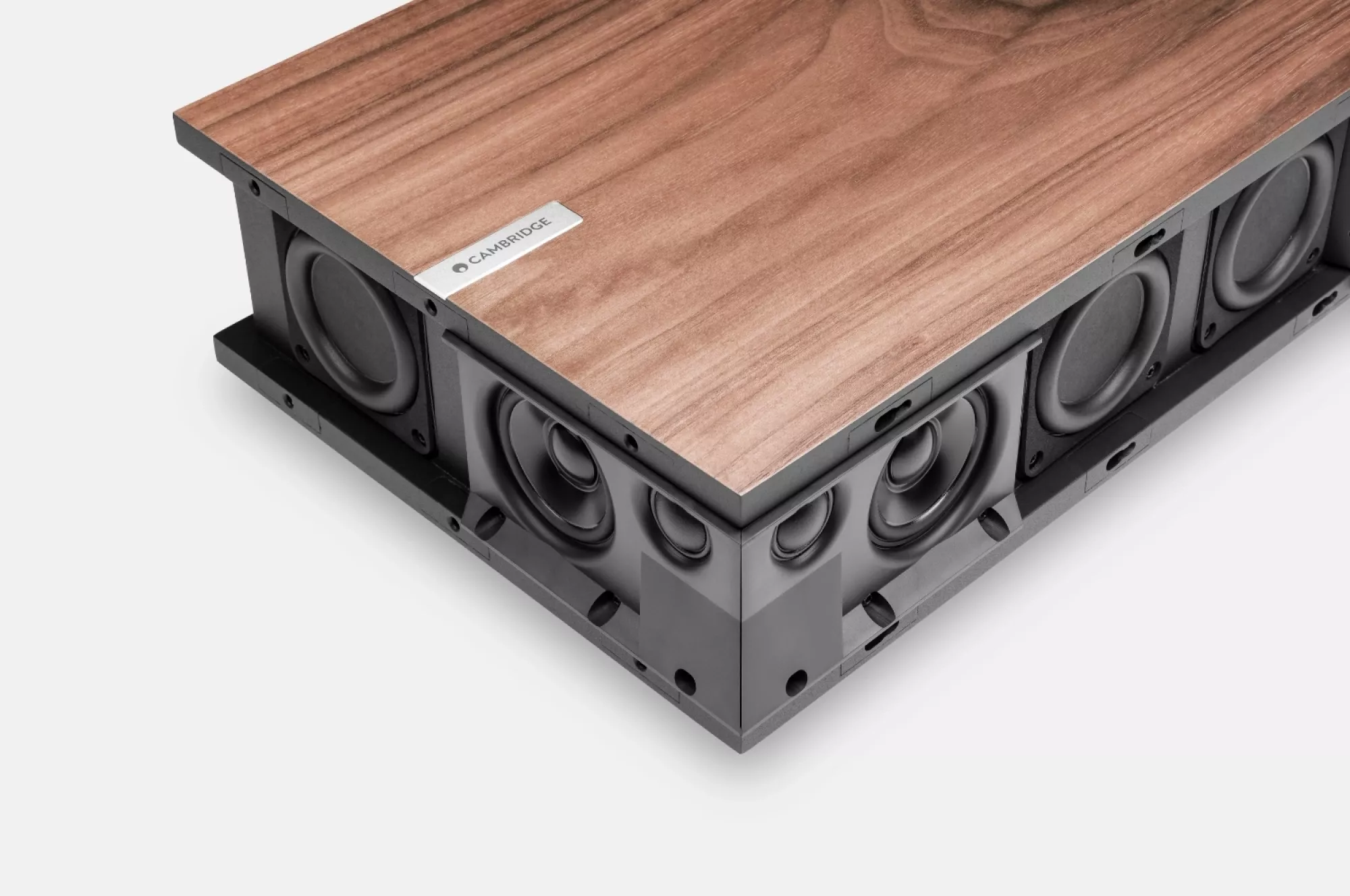 Pohled do konstrukce Cambridge Audio Evo One se dřevěným vrchem nadzdvihnutým nad řadou černých basových, středových a výškových měničů s kovovým štítkem Cambridge
