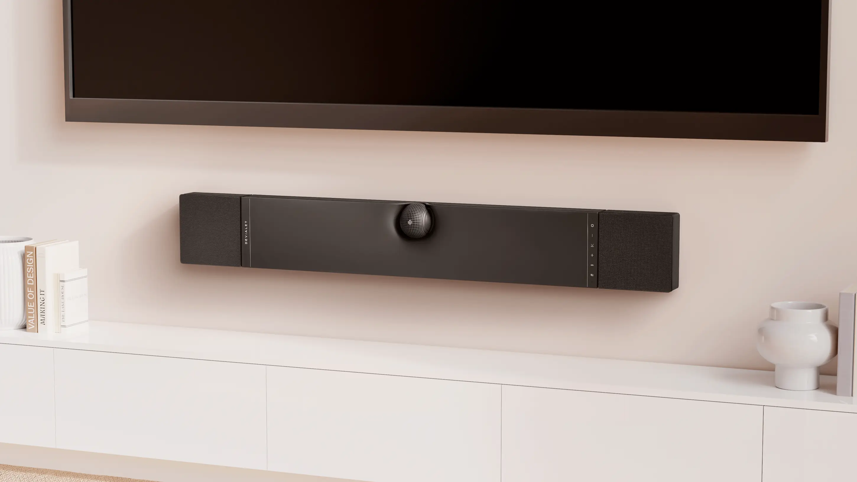 Devialet Dione zavěšený svisle na zdi pod televizí