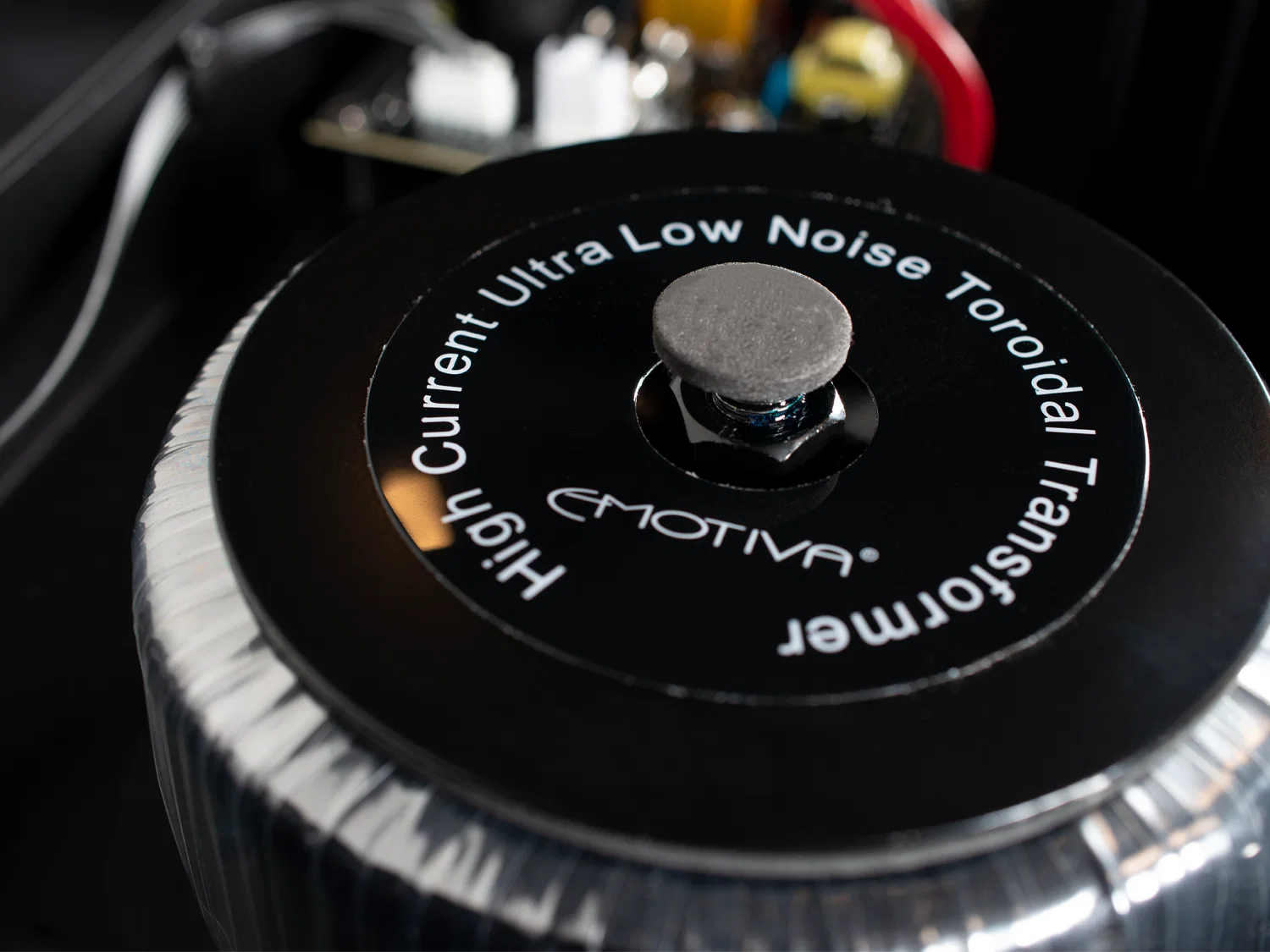 Detail toroidního transformátoru s popiskem High Current Ultra Low Noise Toroidal Transformer uvnitř zesilovače