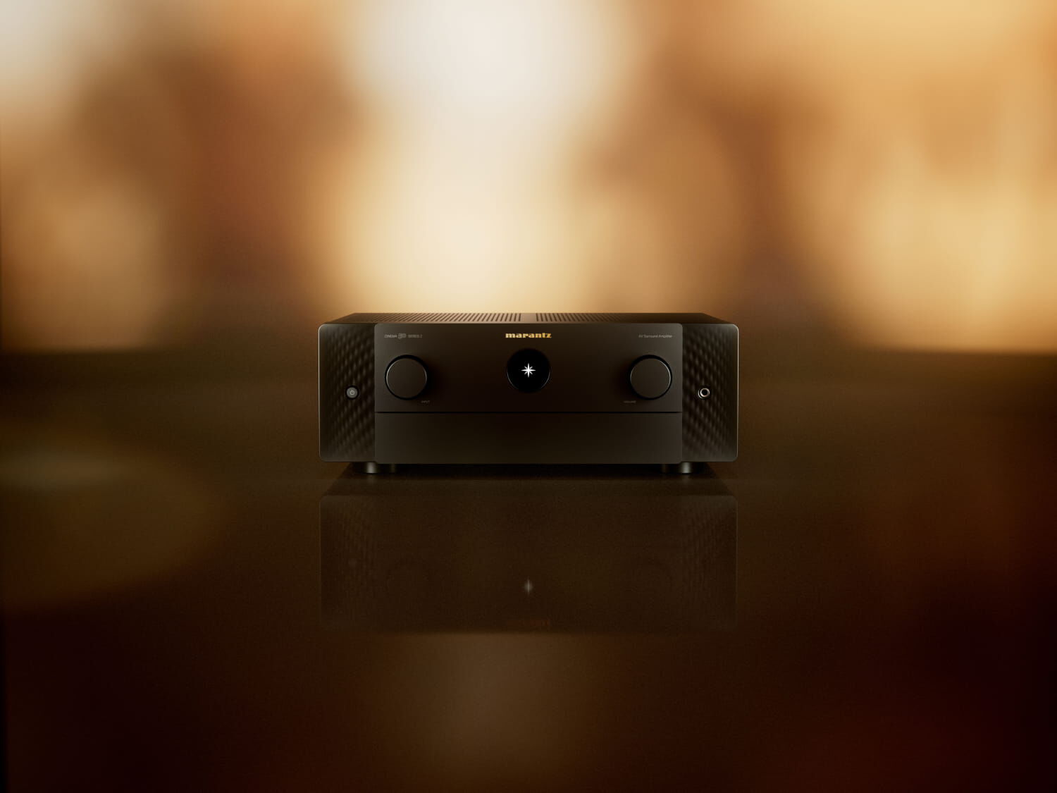 Marantz CINEMA 50 SERIES 2 v černém provedení na lesklé desce, v pozadí rozostřené teplé světlo obývacího pokoje