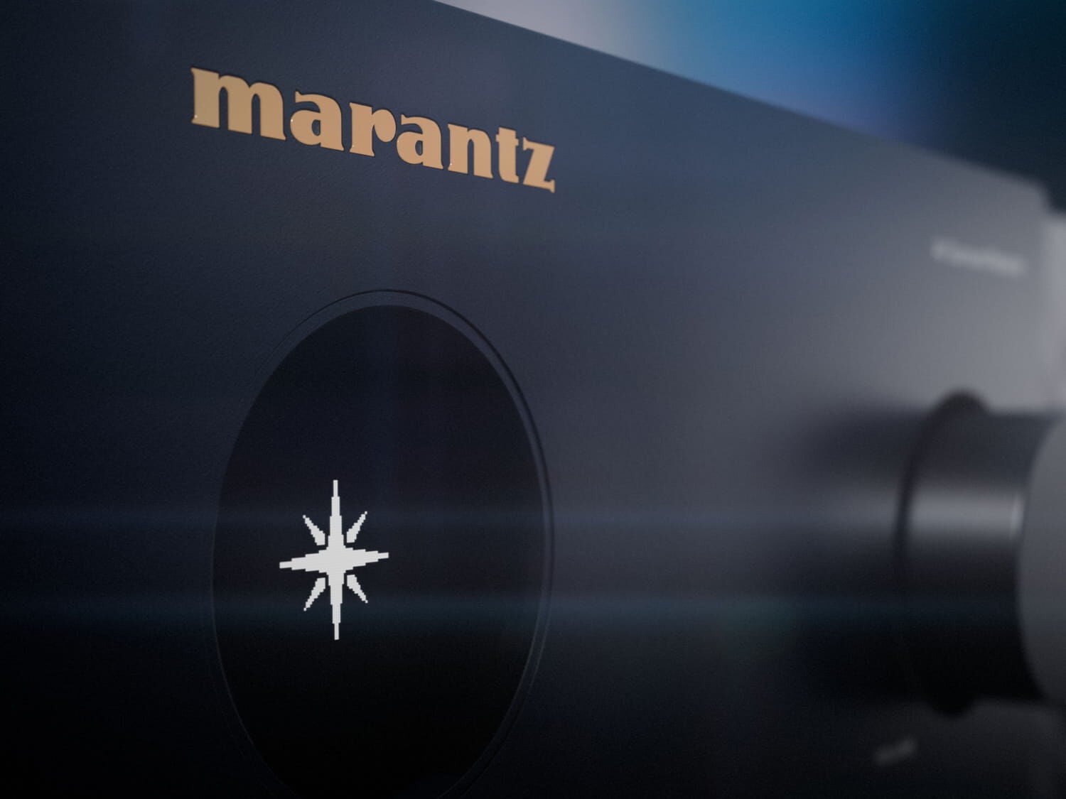 Detail čelního panelu s logem Marantz a kruhovým OLED displejem, na kterém svítí hvězdicový symbol značky