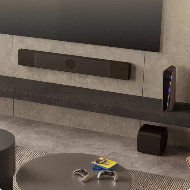 Obývací pokoj se soundbarem KEF XIO na stěně a subwooferem KEF umístěným stranou u konferenčního stolku