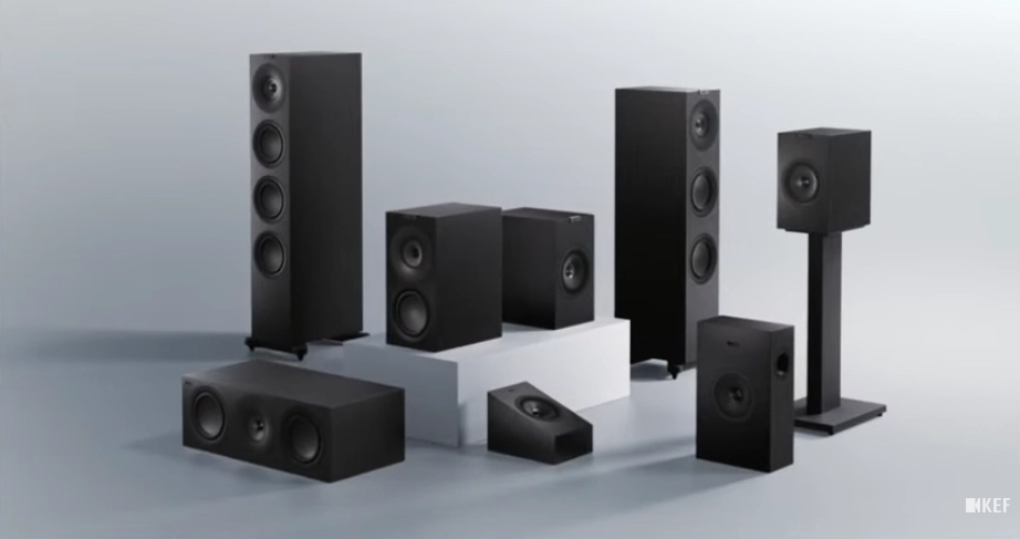 Kompletní rodina reproduktorů KEF řady Q Meta v černém provedení, od sloupových přes regálové a středový kanál po surroundy a subwoofer