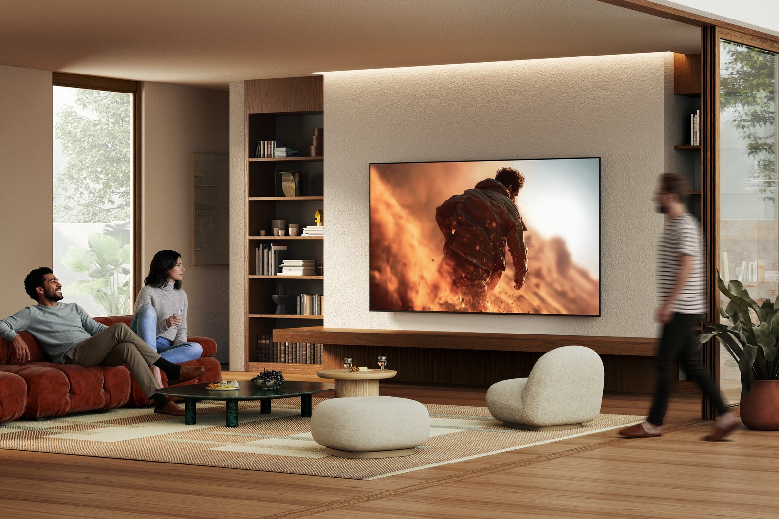 Sony BRAVIA 7 II zavěšená na zdi ve světlém obývacím pokoji, dva lidé sledují filmovou scénu