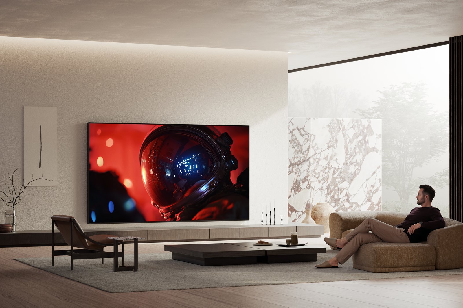 Sony BRAVIA 9 II ve velkém minimalistickém obývacím pokoji, divák na pohovce sleduje filmovou scénu