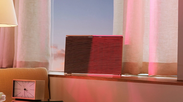 Beosound Level jako přenosný WiFi reproduktor Bang & Olufsen na konferenčním stolku v interiéru