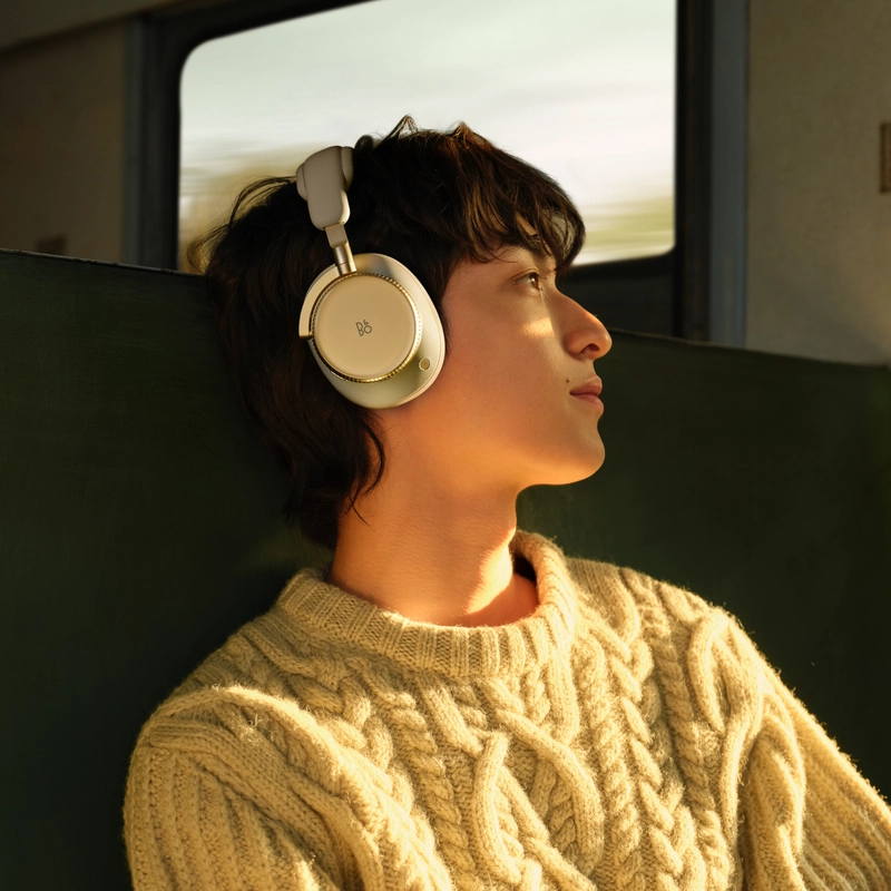 Detail titanového měniče Beoplay H100 za hliníkovou mřížkou