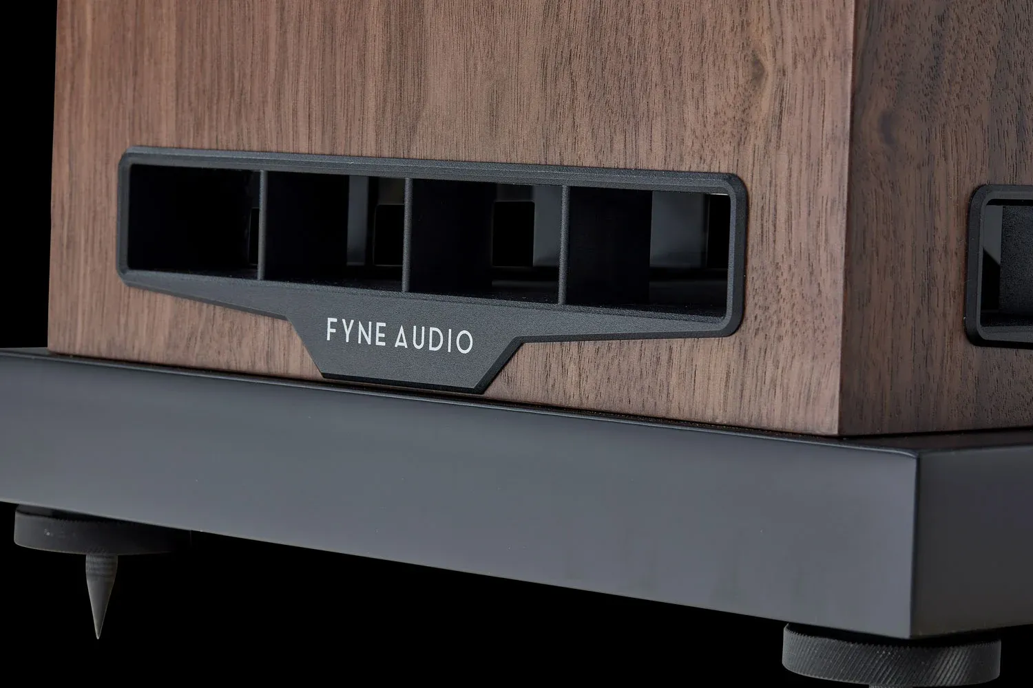 Detail vyústění BassTrax Tractrix Diffuser u podstavce reproduktoru Fyne Audio s badge Fyne Audio