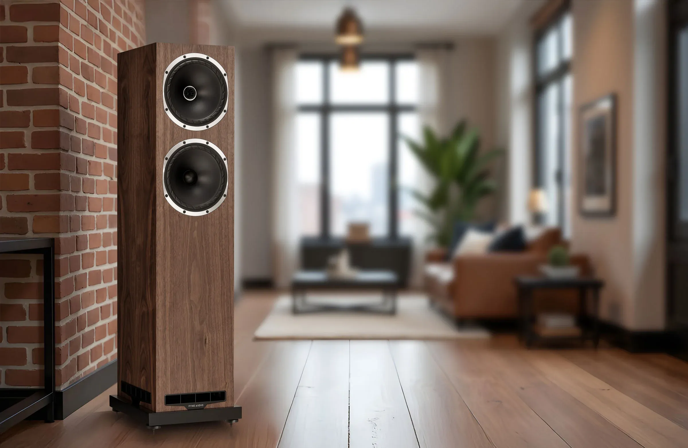 Reproduktor Fyne Audio z řady F500S v ořechovém provedení v loftovém obývacím pokoji s cihlovou stěnou a velkým oknem